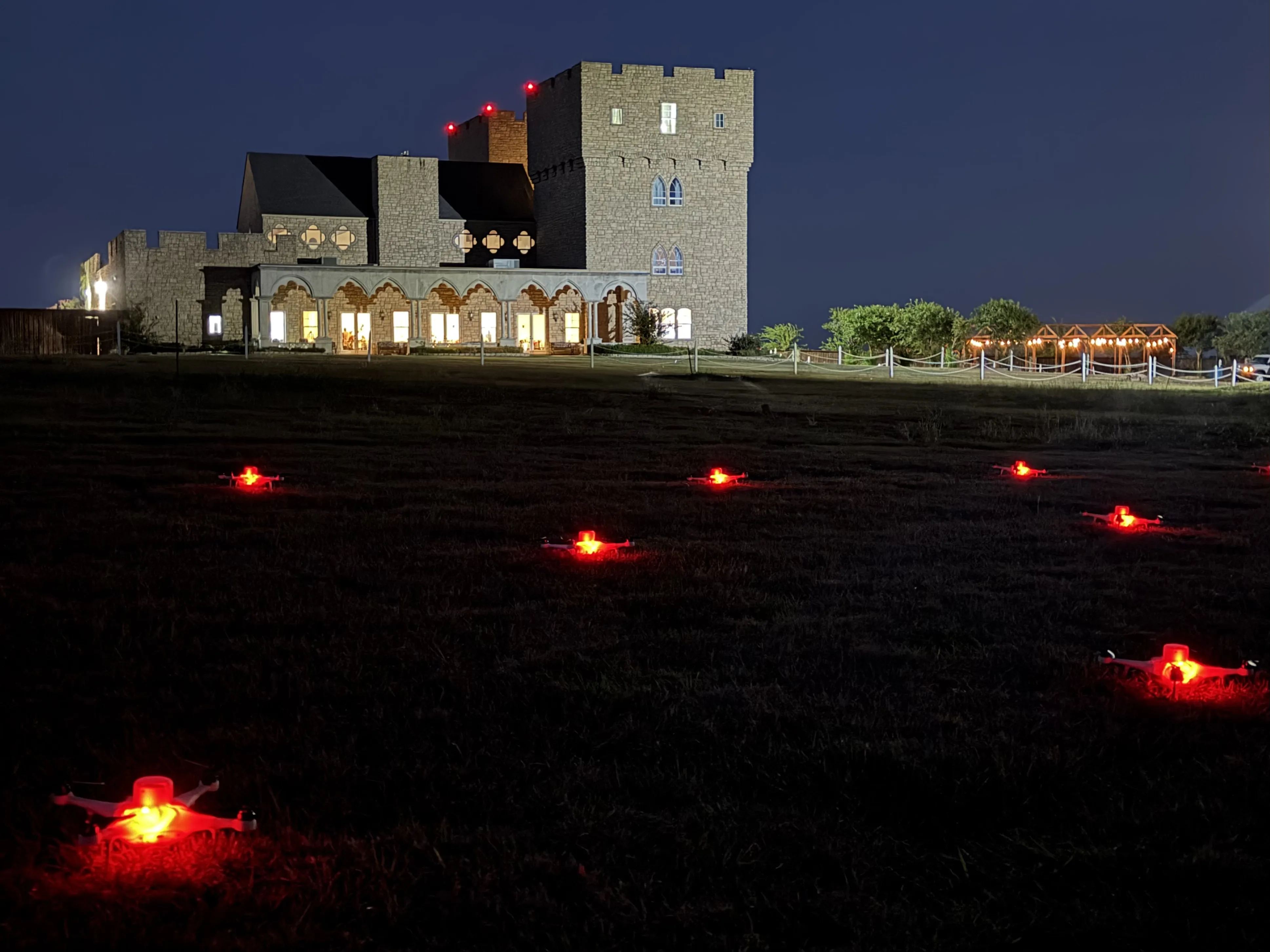 Drones with red lights laid out on the lawn at The Castle at Rockwall before a wedding show
